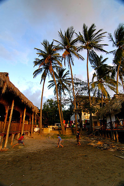 Kids practicing soccer (football) on the beach.