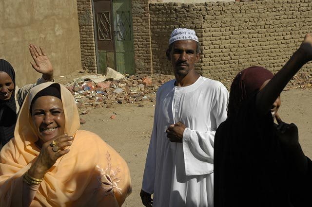 Sudanese women largely stay at home hidden from view, but coming out to wave goodbye to their husbands as they get on a bus seems to be an exception.