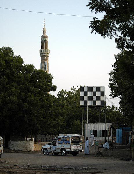 Kerma - Typical scene in a Sudanese village - a mosque, water tower, and a taxi.