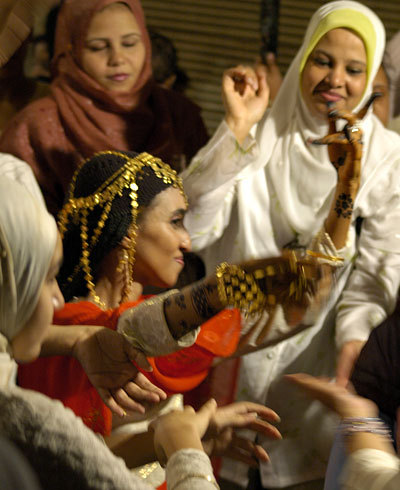 Bride dancing.  It wasn't actually the wedding, but a bridal party the night before the wedding. The henna decorations are traditional, and the gold she's wearing is a traditional dowry gift.