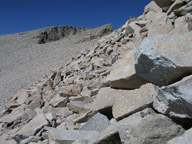 The path winds its way through the rocks leading up to the summit of Whitney.  Whitney is the flat hill to the top left of the photo.