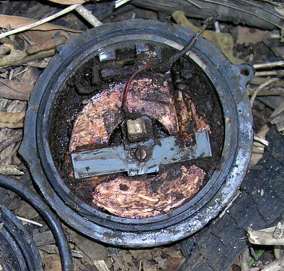 A close-up of a just disarmed mine.  The switch is the square thing with a wire running off of it.  The yellow donut is the TNT.  The detonator has been removed.  It was in that grove you see on the right side of the mine.